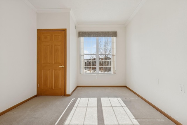 unfurnished room featuring crown molding, baseboards, and light colored carpet