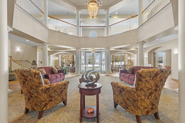 living room featuring ornate columns, stairway, and arched walkways