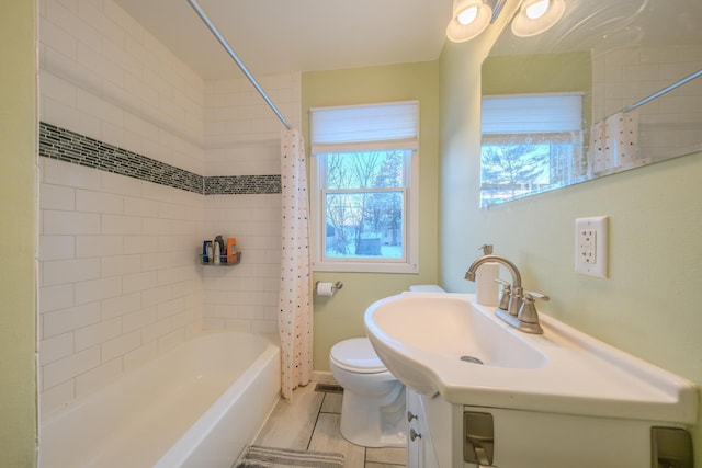 full bathroom featuring sink, shower / bath combination with curtain, and toilet