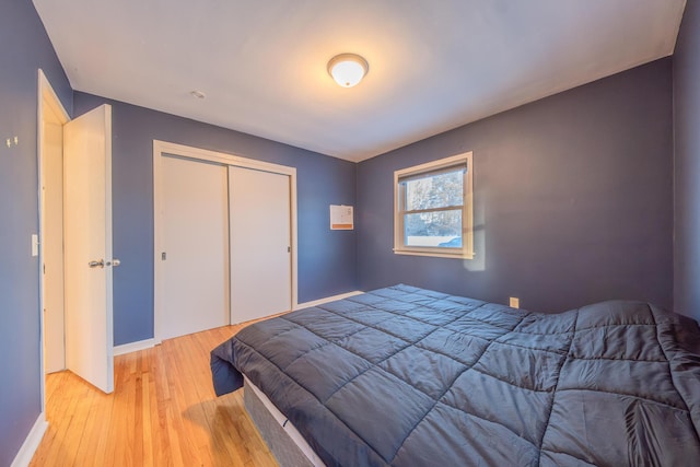 bedroom with light wood-type flooring and a closet