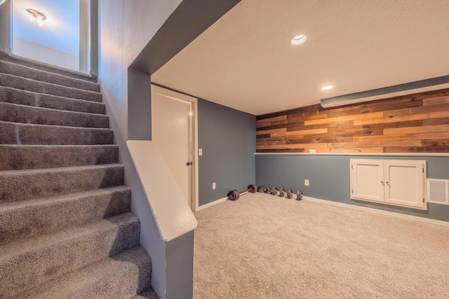 basement with carpet and wood walls