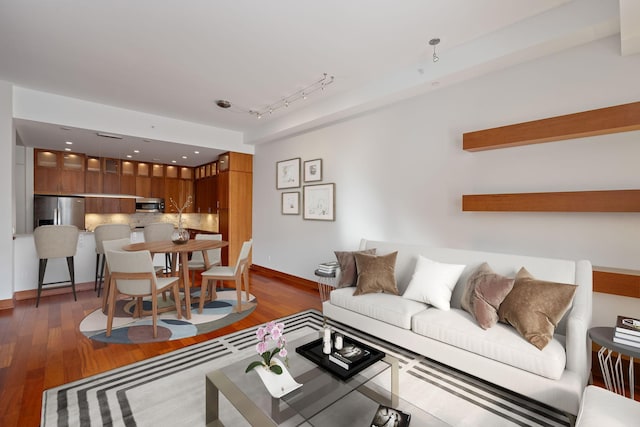 living room with dark wood-type flooring and rail lighting