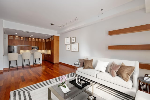 living room featuring track lighting and dark hardwood / wood-style flooring