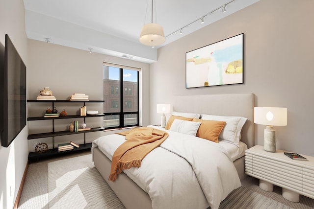 carpeted bedroom featuring rail lighting