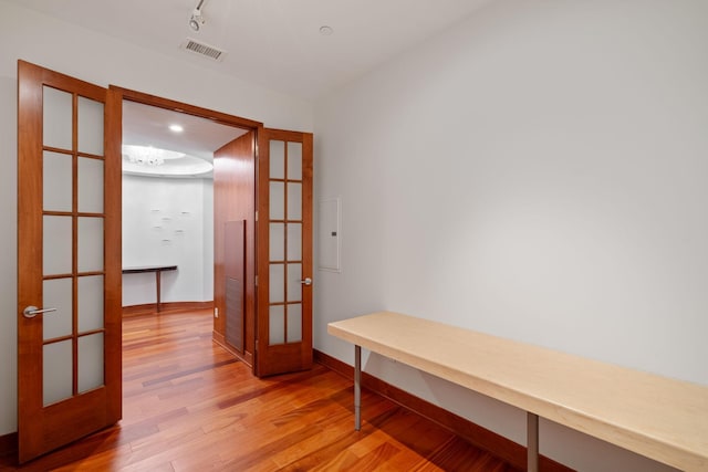 interior space with french doors, rail lighting, and light wood-type flooring