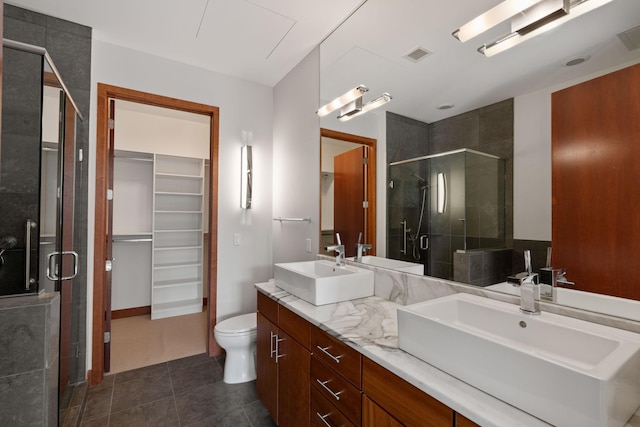 bathroom with vanity, toilet, an enclosed shower, and tile patterned flooring