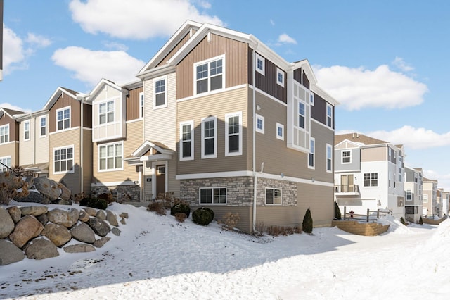 exterior space featuring stone siding, board and batten siding, and a residential view