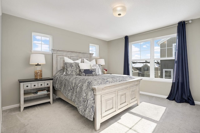 bedroom with light colored carpet and baseboards