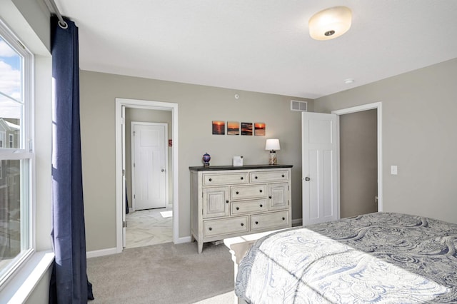 bedroom featuring light colored carpet, visible vents, and baseboards