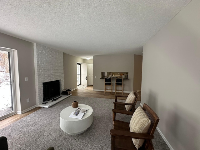 living room featuring a fireplace, a healthy amount of sunlight, and light wood-type flooring