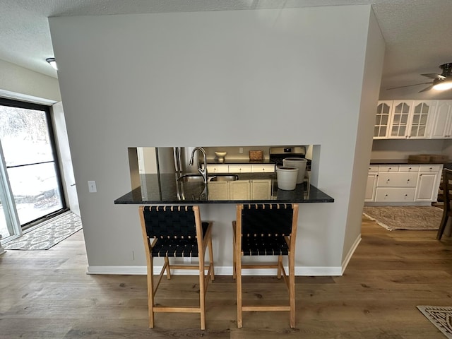 dining area with light hardwood / wood-style floors, sink, and a textured ceiling