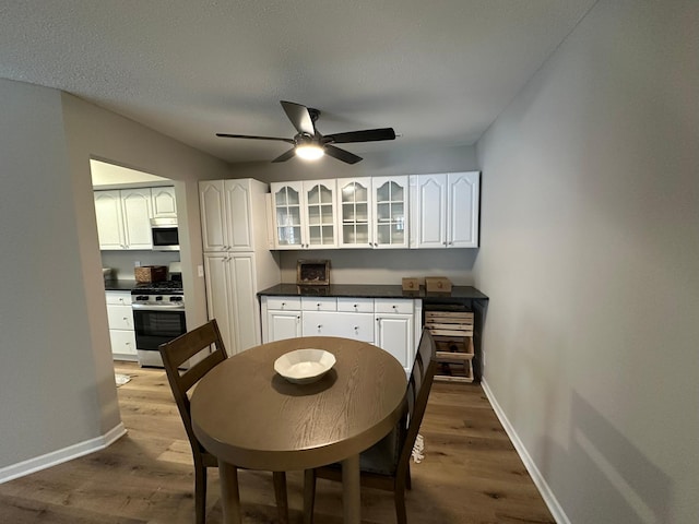 dining space featuring hardwood / wood-style floors, a textured ceiling, and ceiling fan