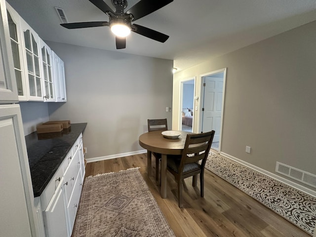 dining space with wood-type flooring and ceiling fan