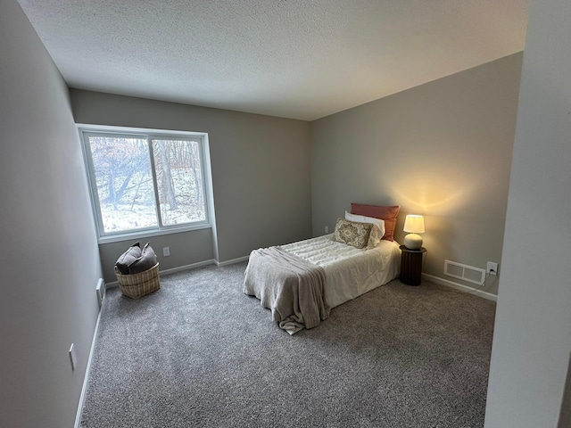 bedroom with carpet floors and a textured ceiling