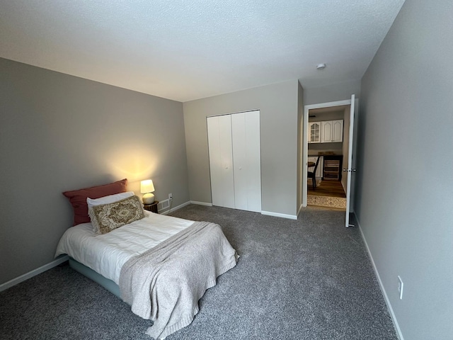 carpeted bedroom with a closet and a textured ceiling