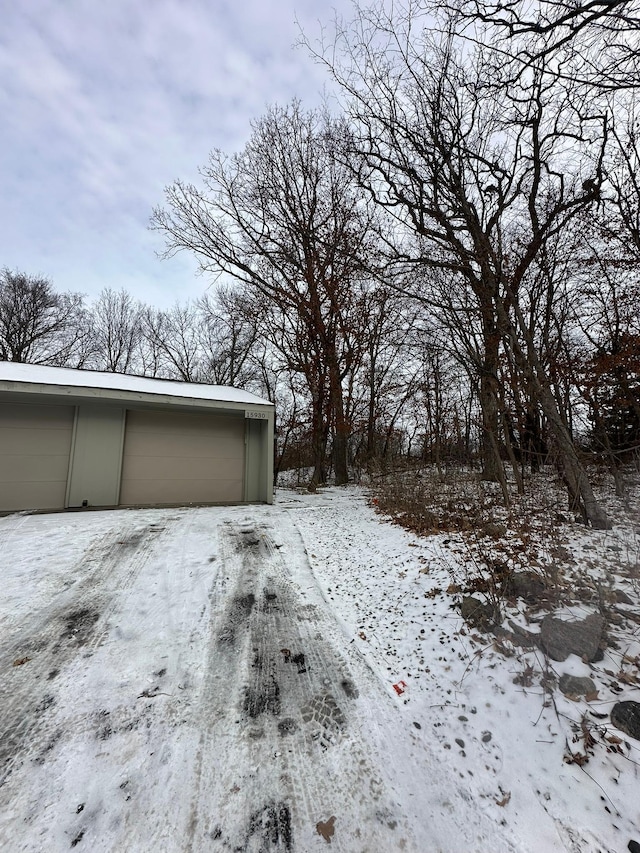 yard covered in snow with an outbuilding and a garage