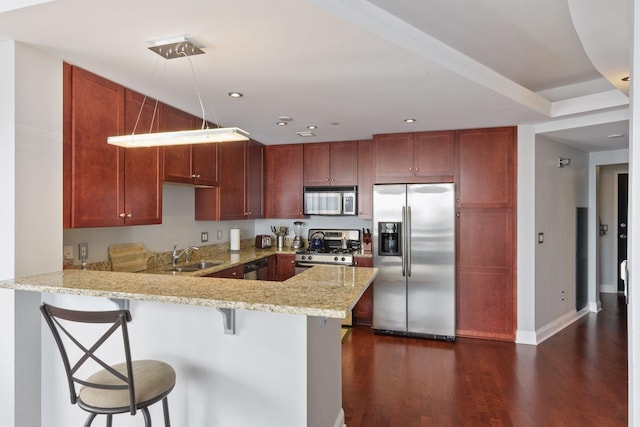 kitchen featuring appliances with stainless steel finishes, sink, a kitchen breakfast bar, and kitchen peninsula