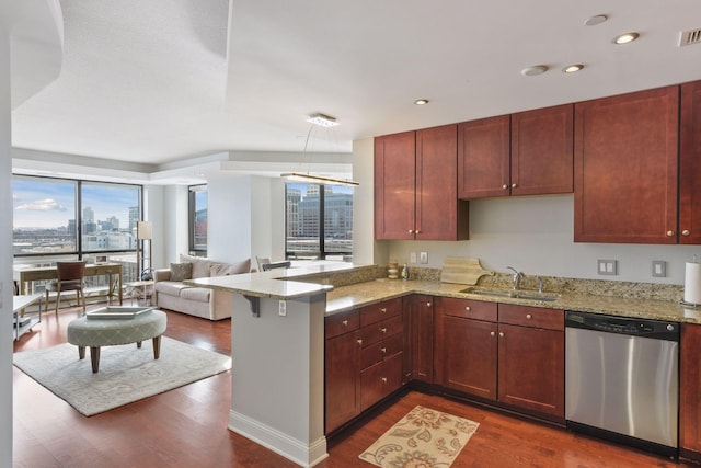 kitchen featuring sink, stainless steel dishwasher, light stone counters, and kitchen peninsula