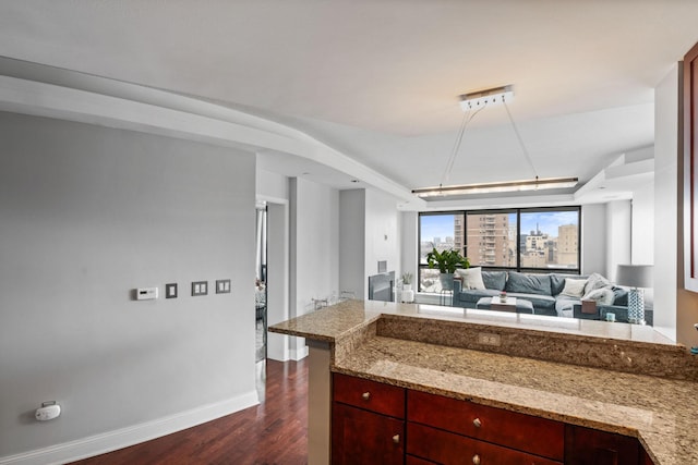 kitchen with light stone counters and dark hardwood / wood-style flooring