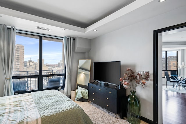 bedroom featuring wood-type flooring and a raised ceiling