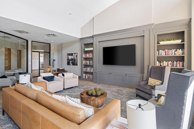 living room featuring high vaulted ceiling and built in shelves