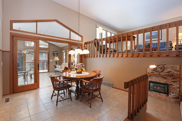 tiled dining room featuring high vaulted ceiling and a fireplace