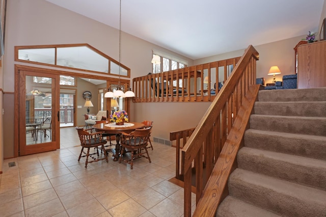 dining space with tile patterned flooring and a towering ceiling