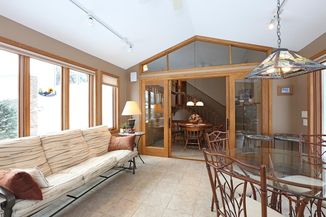 sunroom / solarium featuring french doors, track lighting, and lofted ceiling