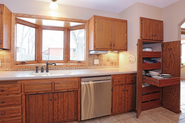 kitchen with tasteful backsplash, sink, light tile patterned floors, and dishwasher