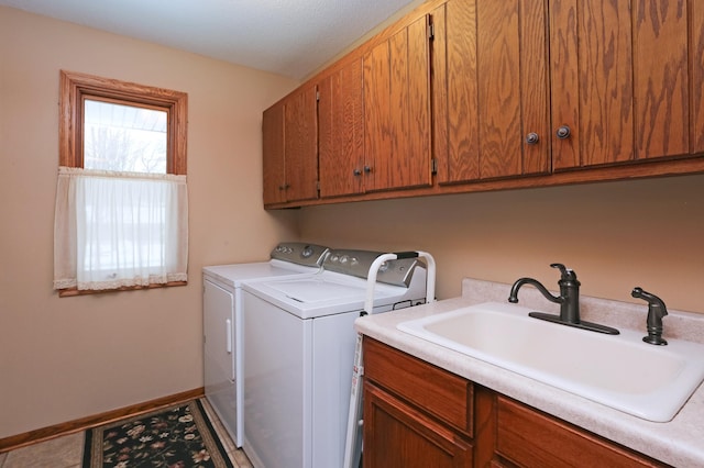 washroom featuring cabinets, sink, and washing machine and dryer