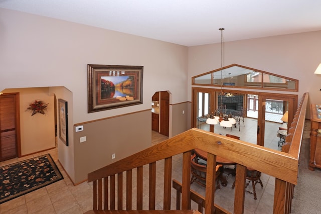 stairway featuring high vaulted ceiling, tile patterned floors, and an inviting chandelier