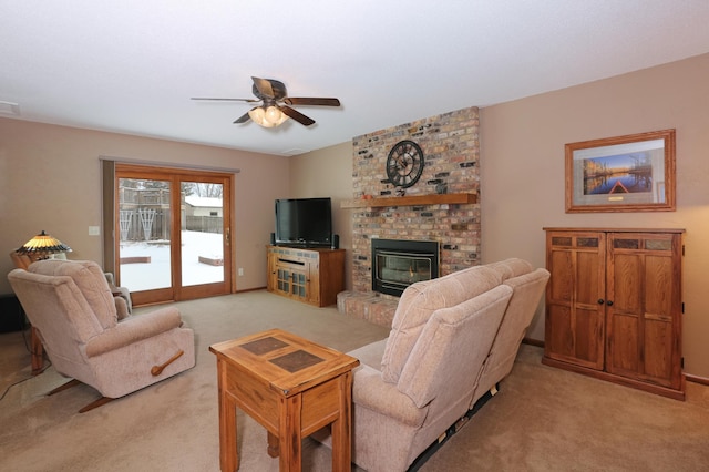 living room featuring ceiling fan, light colored carpet, and a fireplace