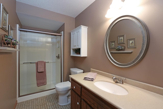 bathroom with tile patterned flooring, vanity, toilet, a shower with door, and a textured ceiling