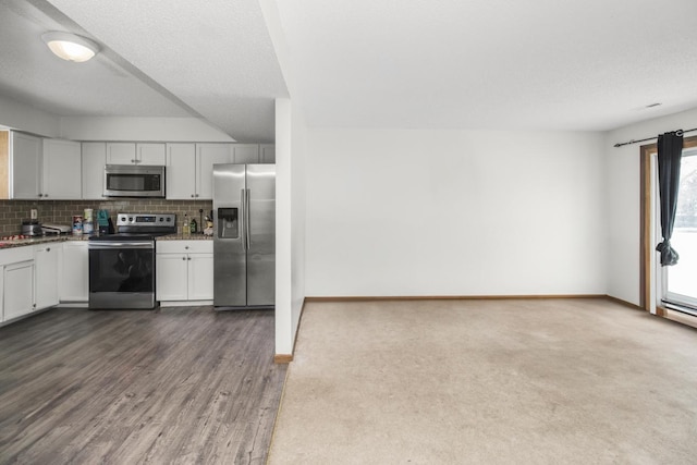 kitchen with stainless steel appliances, white cabinets, backsplash, and baseboards