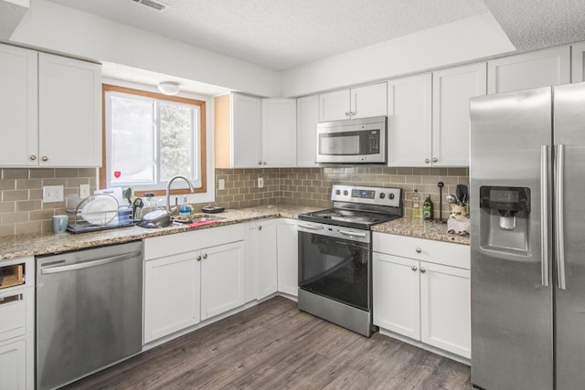 kitchen featuring stainless steel appliances, white cabinetry, and a sink