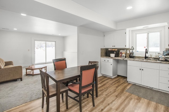 dining room featuring baseboards, light wood finished floors, recessed lighting, and a healthy amount of sunlight