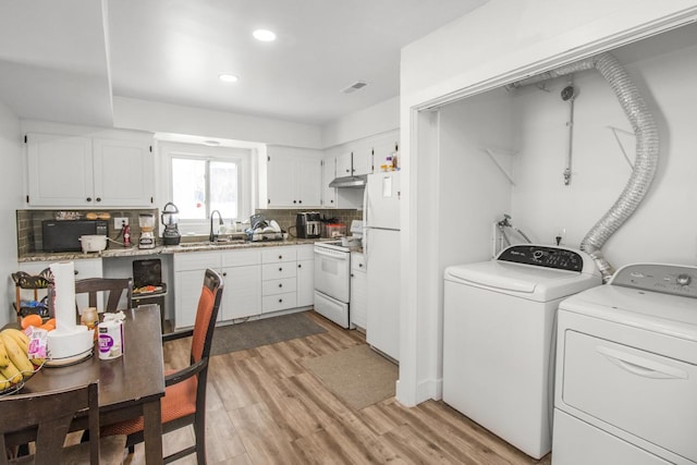 kitchen with tasteful backsplash, washing machine and dryer, white cabinets, light wood-type flooring, and white appliances