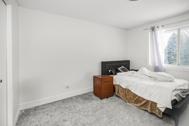 bedroom with light carpet and baseboards