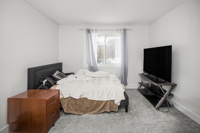 bedroom with light colored carpet and baseboards