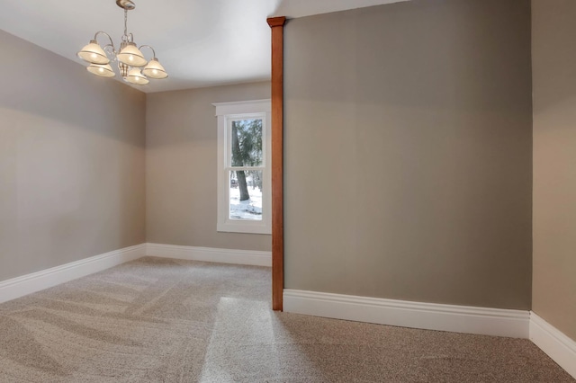 empty room featuring carpet flooring and an inviting chandelier