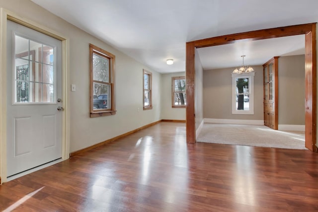 foyer entrance featuring hardwood / wood-style floors and a notable chandelier