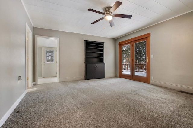 empty room with ceiling fan, light colored carpet, and ornamental molding