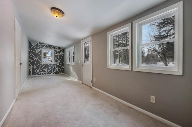 interior space featuring light colored carpet and lofted ceiling