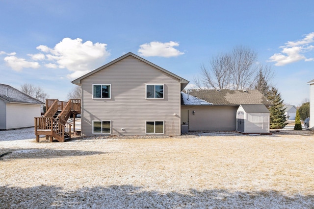 rear view of property featuring a storage shed and a wooden deck