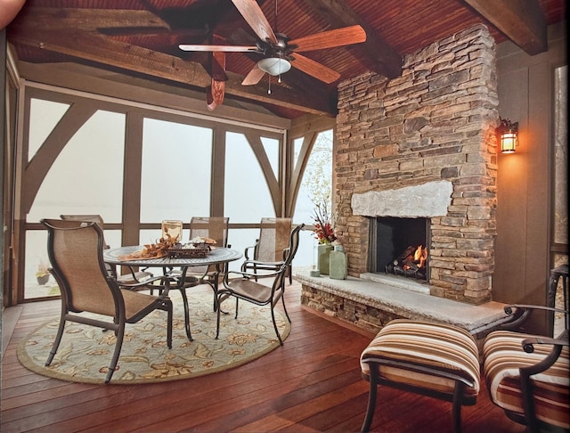 sunroom featuring wood ceiling, beamed ceiling, and an outdoor stone fireplace