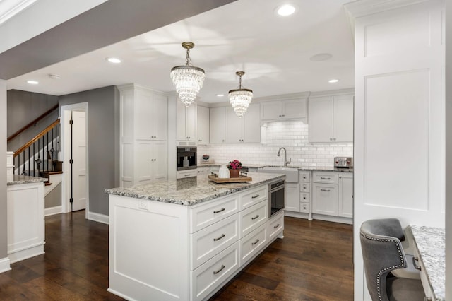 kitchen featuring white cabinetry, hanging light fixtures, and a kitchen island