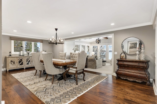 dining space with ornamental molding, dark wood-type flooring, and an inviting chandelier