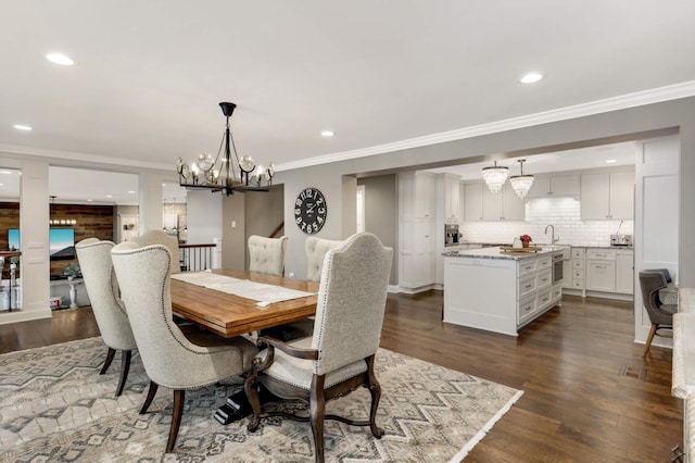 dining area featuring sink, crown molding, and dark hardwood / wood-style floors