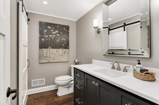 bathroom featuring vanity, wood-type flooring, and toilet