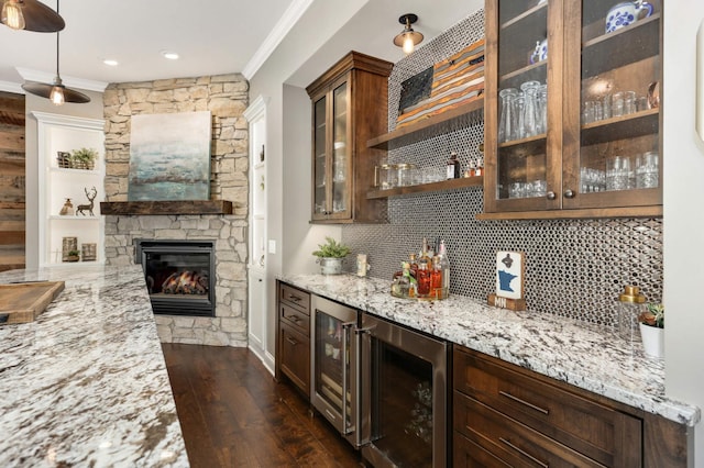 bar featuring light stone counters, ornamental molding, and beverage cooler